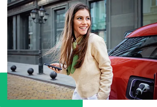 Kobieta przy samochodzie elektrycznym sprawdza na telefonie warunki finansowania na platformie mamyGO